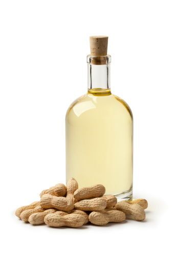 Bottle Of Peanut Oil And Peanuts On White Background Peanut-Oil